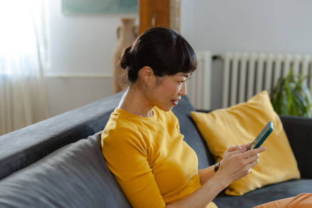 istock Japanese woman using smartphone and watching online content at home 2173917535