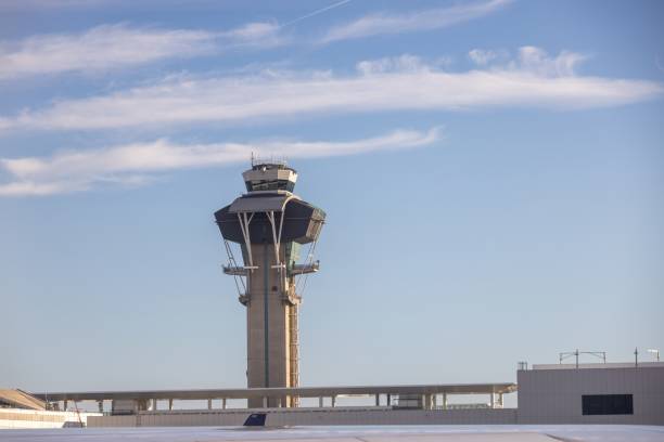 Airport tower with a blue sky in the background. The building has a unique shape and he is a tower. Airport control tower stood tall, overseeing the bustling activity on the runways below