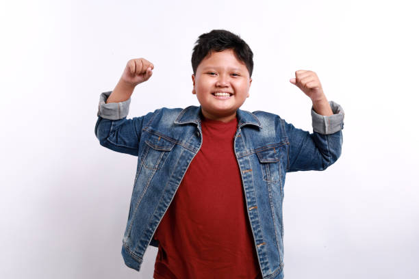 istock Cheerful little boy standing with happy expression, feeling strong, celebrating victory isolated on white background 2173920391