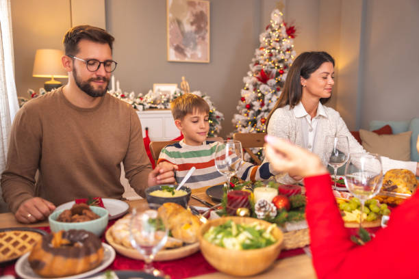 istock Family praying before having Christmas dinner at home 2173924644