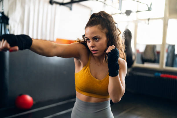 istock Female kickboxer shadowboxing during a practice in the gym 2173926760