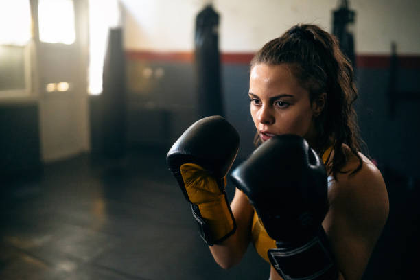 istock Female kickboxer shadowboxing during practice in the gym 2173926772
