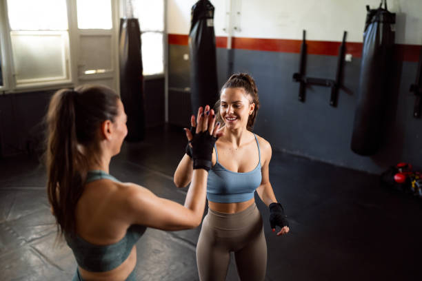 istock Female kickboxer with an coach interchange high-five during an practice 2173927557