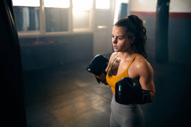 istock Young female kickboxer with boxing gloves, during practice 2173928879