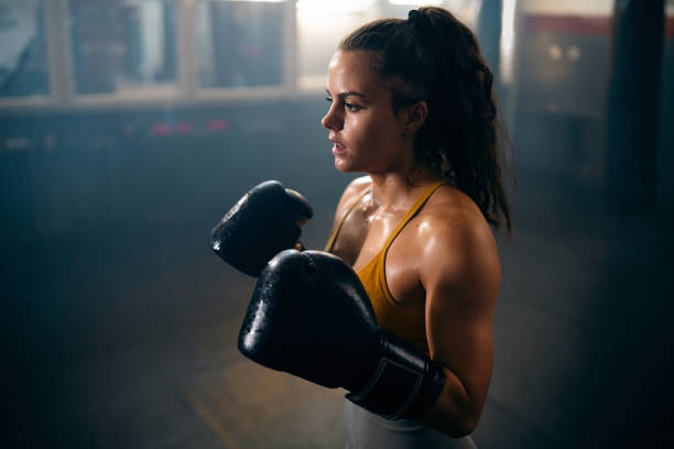 istock Young female kickboxer with boxing gloves, during practice 2173928881