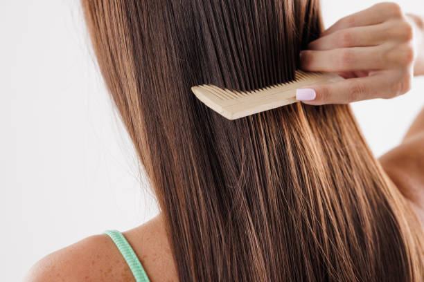 istock Combing Long Brown Hair with Wooden Comb 2173934975