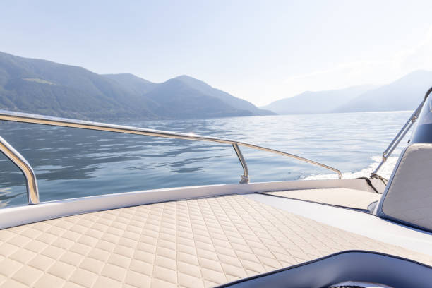 A peaceful boat ride on a calm mountain lake, surrounded by majestic peaks and soft clouds. Clear skies and reflections create a serene atmosphere.