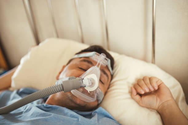 istock Man Sleeping With Cpap Machine on for Sleep Apnea 2173937474