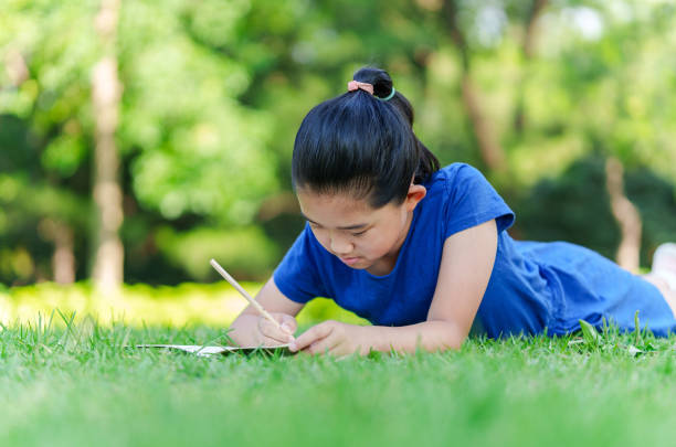 istock Little Girl Writing on Lawn 2173937651