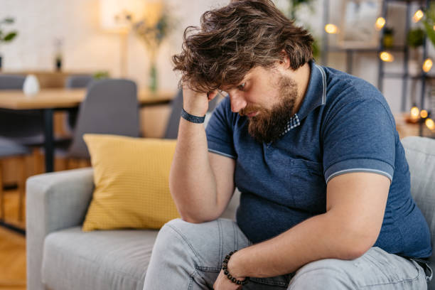 Sad Young Man Sitting At Home On The Sofa
