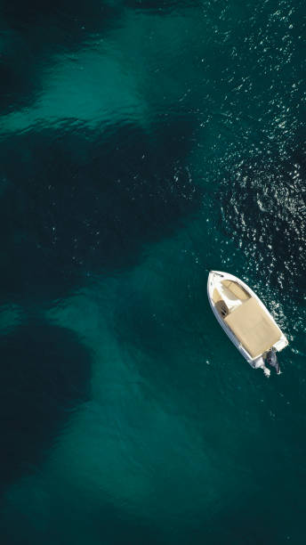 istock A lone small boat anchored in the tranquil emerald depths 2173941213