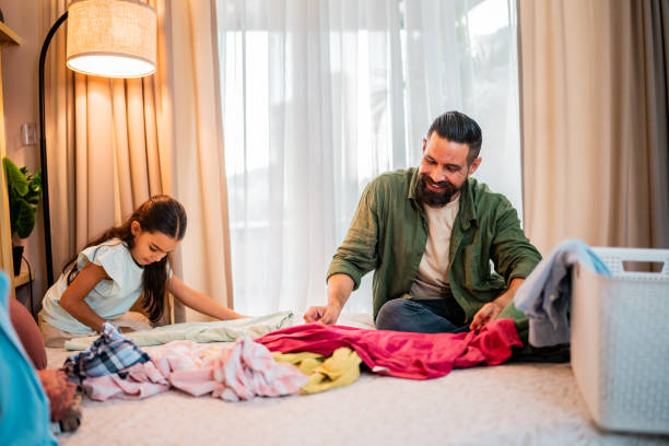 istock Father and daughter talking while organizing clothes at home 2173952451
