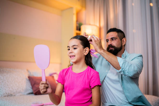 istock Father tying daughter's hair at home 2173952684