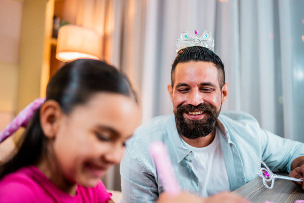istock Child daughter putting makeup on father at home 2173952943