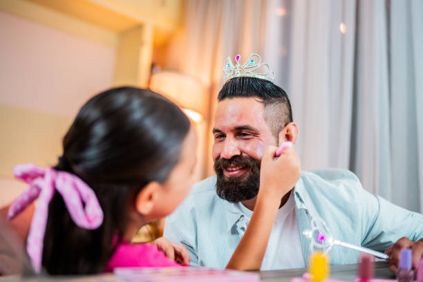 istock Child daughter putting makeup on father at home 2173952979