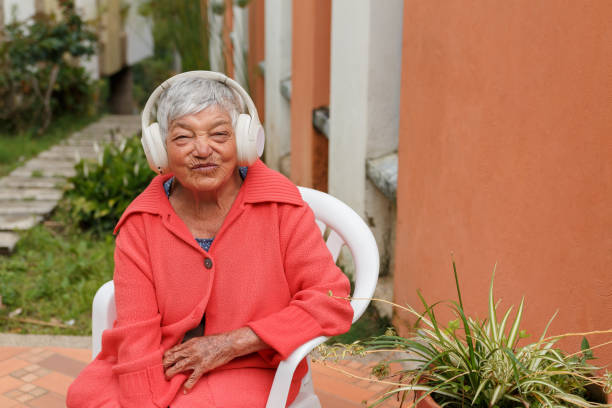 istock Elderly woman enjoying music through headphones while seated outdoors, representing active aging and joyful moments of relaxation, highlighting senior lifestyle and wellness 2173953059