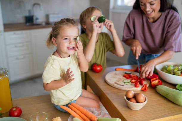 istock Happy kids having fun whit vegetables while making healthy meal whit their mother 2173954471