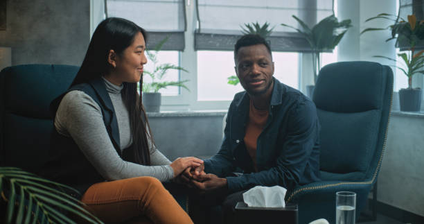 istock Happy multiethnic couple sit on chairs holding hands after quarrel on couples therapy 2173954802