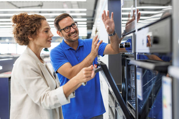 istock Salesman assisting customer in a modern kitchen appliance store 2173956973