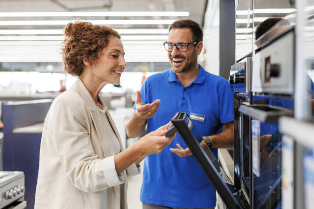 istock Salesman assisting customer in a modern kitchen appliance store 2173956990