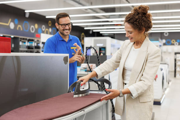 istock Woman testing an iron in an electronics store with assistance 2173957042