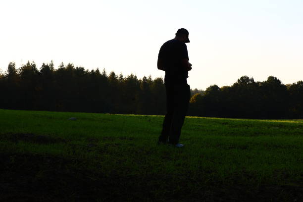 a man stands in a meadow in the shade