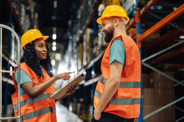 istock Enthusiastic multiracial workers strategizing logistics in warehouse aisle 2173958909
