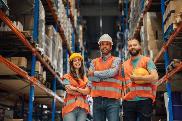 istock Warehouse workers standing together wearing safety gear inside 2173958925