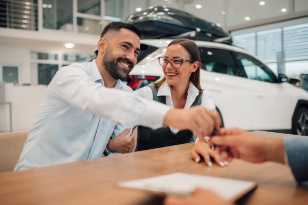 istock Couple happily signing papers, confirming car ownership. 2173958938