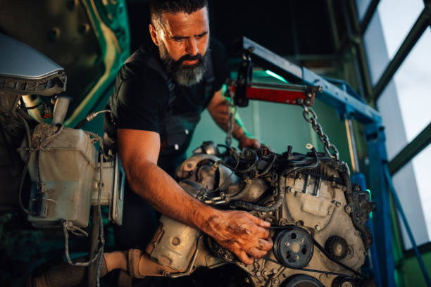 istock Mechanic examining car engine parts in a well-lit garage 2173958949