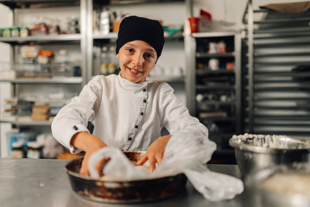 istock Young girl chef preparing dough with utensils in kitchen setting 2173959083