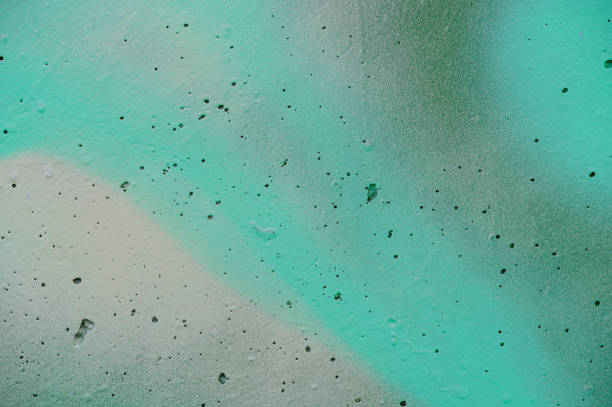 Close-up of an abstract surface with green and yellow brushstrokes, accented by small holes. The image showcases the varied textures and vibrant colors, creating a dynamic and artistic composition.