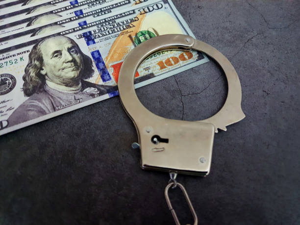 istock Handcuffs on the hundred-dollar bills. 2173965357
