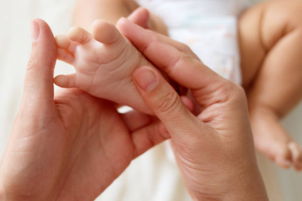 istock Unrecognizable anonymous mother gently doing massage on her cute unknown baby foot prevention of flat feet development muscle tone and dysplasia 2173970241