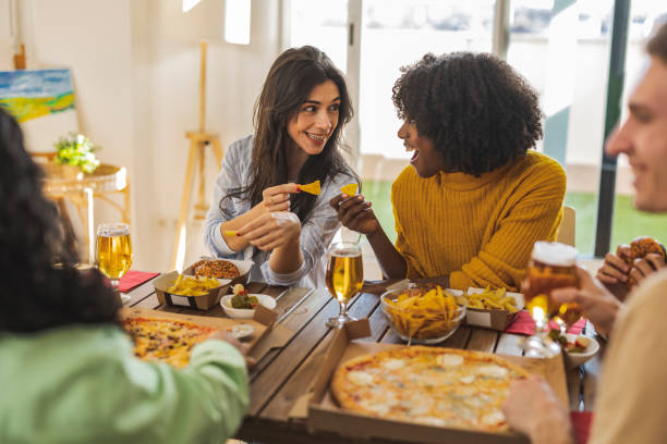 istock Friends Sharing Pizza and Snacks at Indoor Gathering 2173971820