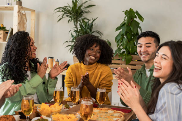 istock Smiling Friends Clapping and Enjoying Pizza at Indoor Gathering 2173971858
