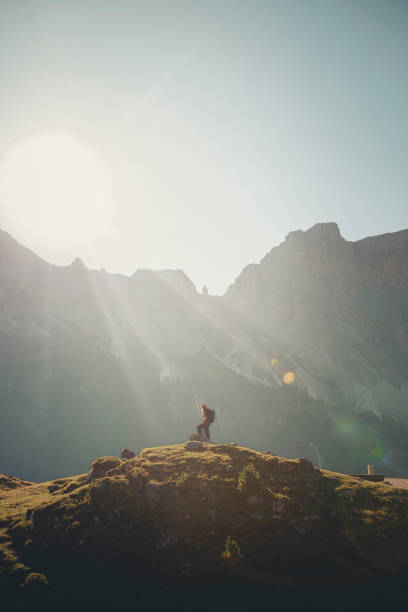 istock Young woman stands on boulder in mountain meadow 2173972217