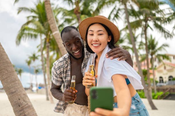 istock Multiracial Couple Taking Selfie with Beer on Beach 2173972411