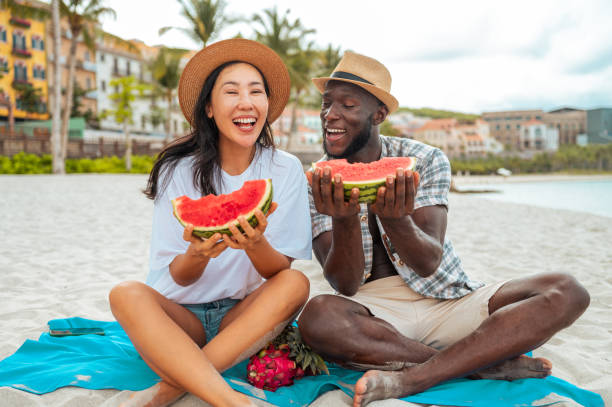 Joyful Couple Sharing Watermelon on Beach