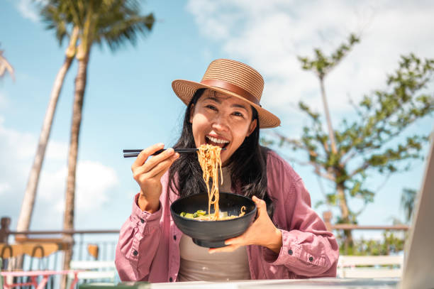 istock Asian Female Traveler Multitasking with Cuisine and Tech 2173972681