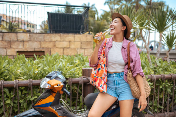 istock Joyful Asian Traveler Savoring a Cold Beverage 2173972764