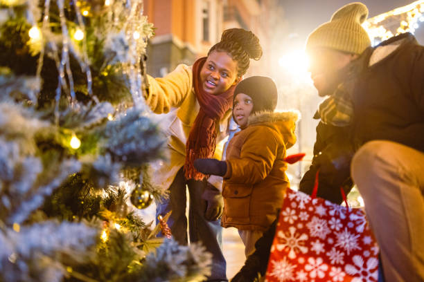 istock Family Decorating Christmas Tree on Winter Evening 2173972987