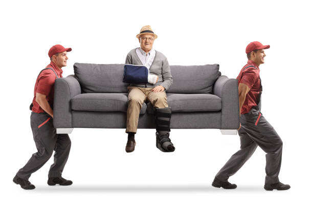 istock Movers carrying sofa with injured senior man 2173973205