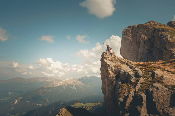 istock Young women hikers stand on cliff above valley 2173974290