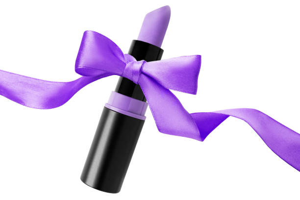 Matte lavender color lipstick tube tied with purple silk ribbon bow isolated over white