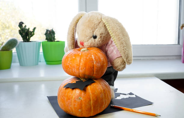Toy bunny prepares decorations for Halloween