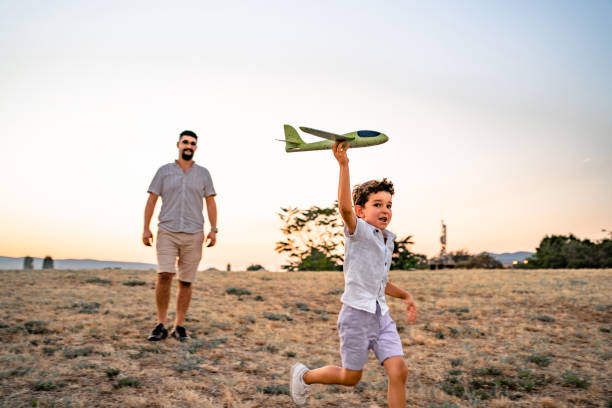 istock Little girl running with plane while dad goes behind her 2173988004