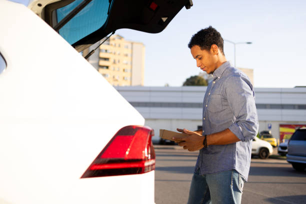 istock Man packing a box into his car trunk 2173988249
