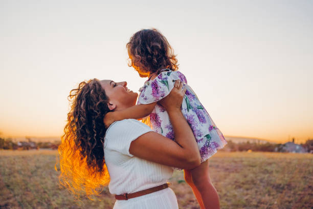 istock Mom with daughter on field at sunset 2173988440