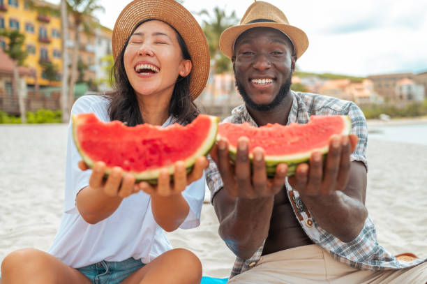 istock Joyful Couple Sharing Watermelon Slice at Beach 2173988608